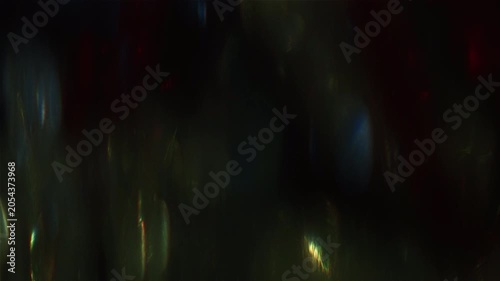 Abstract dark background with shimmering light leaks and lens flares.