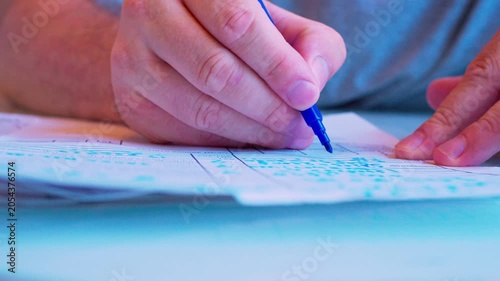 Cinematic macro of a hand filling a survey or job application form. Defocused background, soft window light. Visualizes questionnaire, voting, human resources hiring process and research.