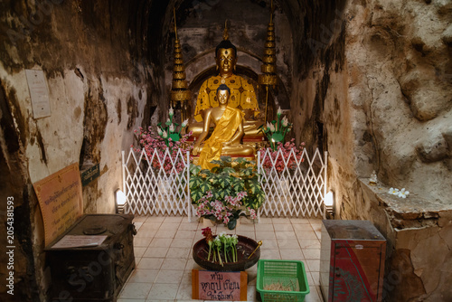 Photography Golden Buddha statues adorn a cave shrine in Wat Umong, Chiang Mai, Thailand