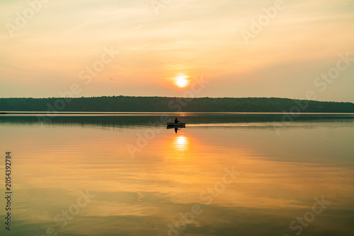 Sunset on a river with a single kayaker