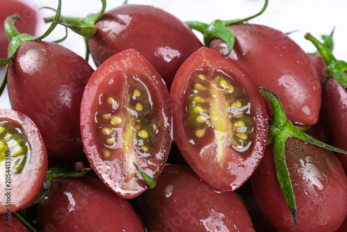 Foto Fresh Red Tomatoes on Vine with Water Droplets, Cut Cross-Section