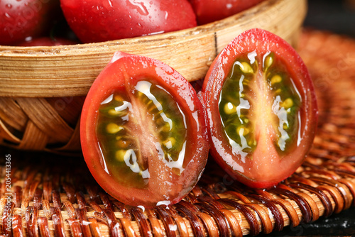 Vászonkép Fresh Ripe Tomatoes Sliced Half Cross Section in Wooden Basket