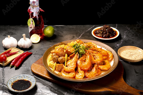 Foto Spicy homemade Asian prawn stir-fry with vegetables and meatballs in wooden bowl