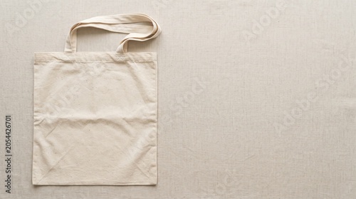 Blank Cotton Tote Bag Flat Lay on Natural Fabric Background with Copy Space, Eco Friendly Shopping Concept