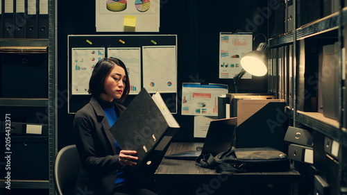 Fotografie Law enforcement personnel reopening old criminal cases with similar forensic evidence as the ongoing investigation, Agent reviewing classified information to uncover new leads