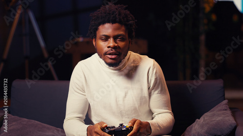 Foto Cheerful gamer feeling excited after finally defeating all enemies and winning, celebrating, Satisfied african american man congratulating himself after finishing videogame