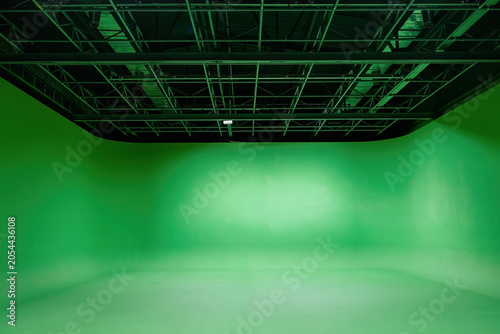 Empty modern professional video production chroma key studio with green screen backdrop