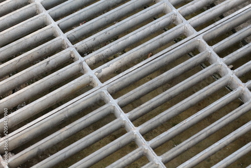 Foto Close-up view of a weathered metal grate with parallel bars and intersecting lin