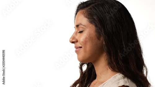 A serene woman meditates peacefully in a calm environment with her eyes closed.