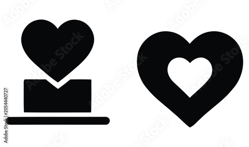 Obraz na płótnie Two black heart shapes one solid and one with a white heart cutout against a whi