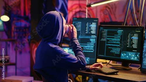 Schilderij op canvas Hacker drinking coffee at underground bunker desk while using network vulnerabilities to exploit servers, trying to break computer systems at night, Lone wolf cybercriminal breaching networks