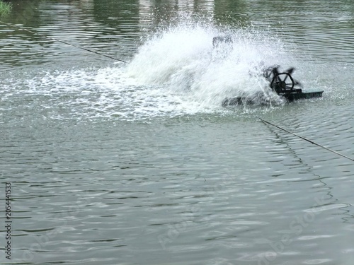 Water aeration turbine churning up a storm of white spray on the surface of a pond