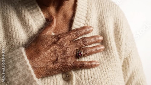A person with a serious expression clutching their chest in discomfort in a video about health issues.