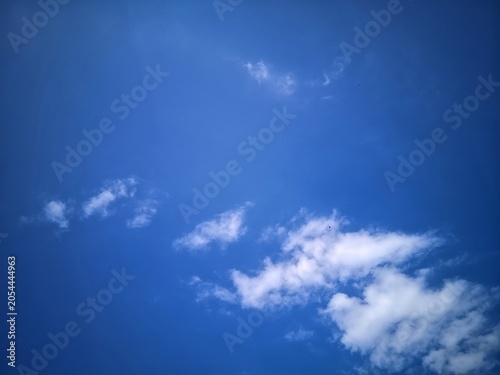 Fotografija This image shows a view of a clear blue sky with a few scattered thin white clouds