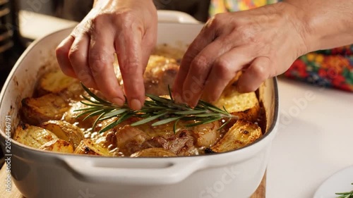 A person preparing a delicious potato casserole dish in the kitchen with a video