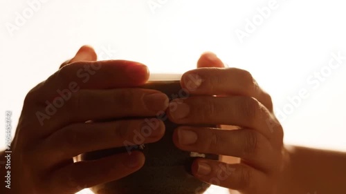 A person holds a coffee mug in their hands in a video about morning routines