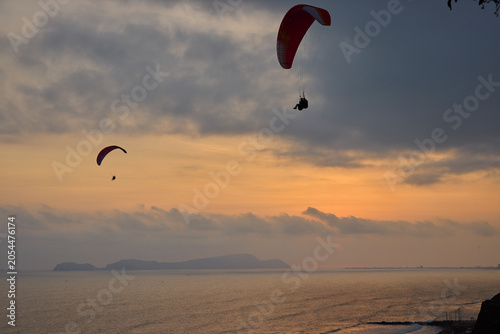 Photography Chasing the last light — paragliders drift in silent communion across a burnishe