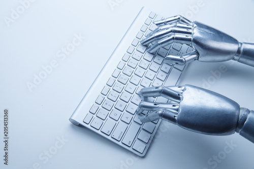 Robotic hands typing on keyboard for artificial intelligence and automation concept