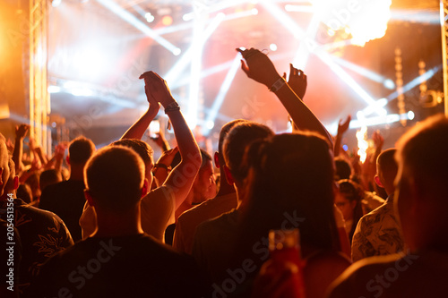 Rock band playing on the stage at summer night concert	
