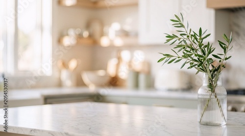 Fresh olive branch in a ribbed glass vase on marble. Blurred pastel kitchen background serves as wide copy space for web and poster design.