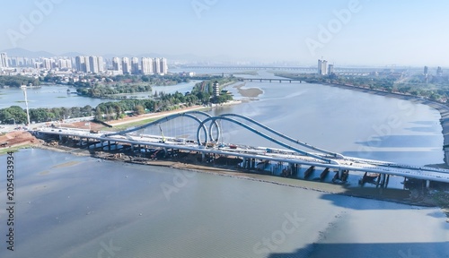 Photos Modern Blue Arch Bridge Over River with City Skyline Aerial View