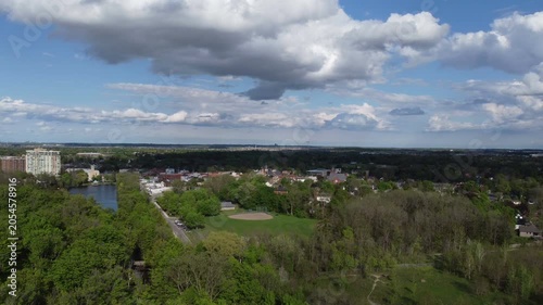 Aerial view of Milton, Ontario, Canada as shot from a drone on a mixed sunshine and clouds spring day in May, 2022. Rising shot east view of Mill Pond, Rotary and Livingston Parks.