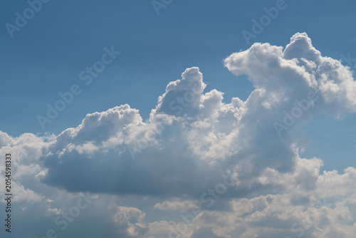 Foto Dramatic cumulus clouds against a blue sky with soft sunlight