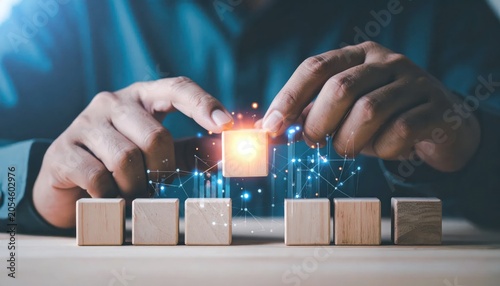 Person placing glowing wooden block, connecting it to other blocks. Business concept