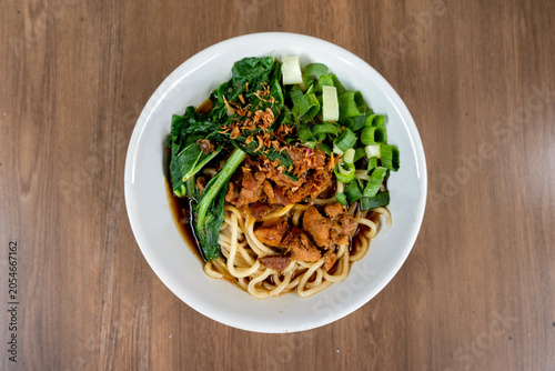 Traditional Mie Ayam Served in White Bowl on Wooden Background