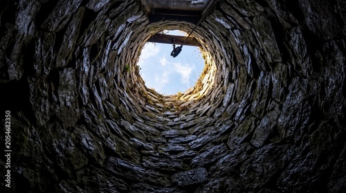 View from inside dark well looking up to bright light opening