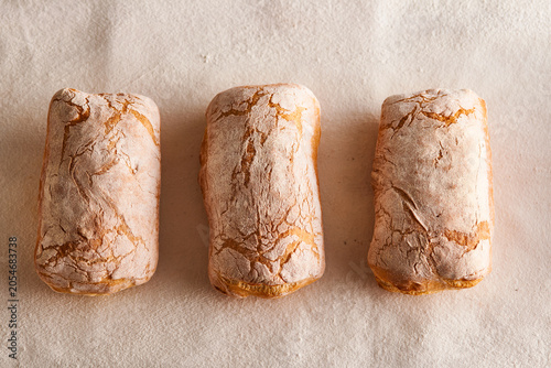 Bild auf Leinwand Freshly Baked Artisan Italian Ciabatta Bread with Slices on Textured Linen Table