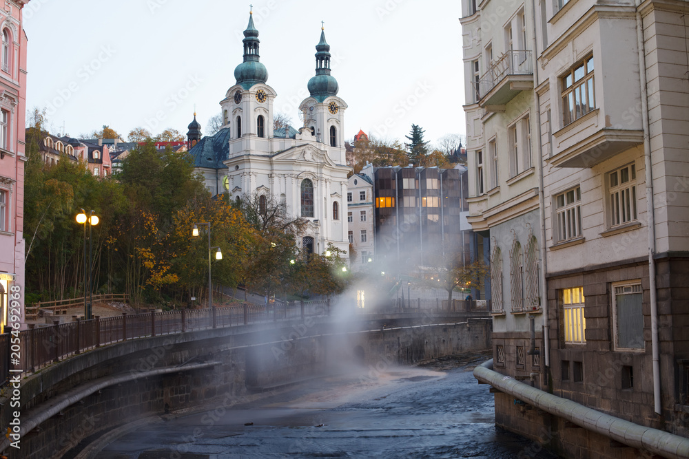 Naklejka premium Autumn view of Karlovy Vary with Church of St. Mary Magdalene above Tepla River, Czech Republic. g.