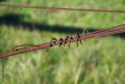 Obraz na płótnie close up of old rusty barbed wire farm fence