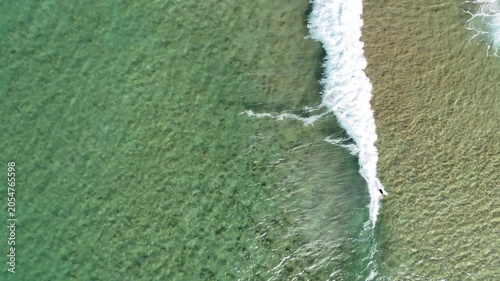 Drone video aerial view of waves crashing onto the shore at a beach in Sydney Australia in Summer 