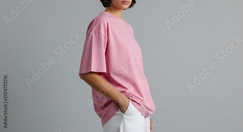 Pink oversized t-shirt on a woman standing profile casual fashion studio shot against grey background