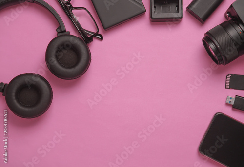 Equipment of modern photographer on a pink background. Top view. Flat lay