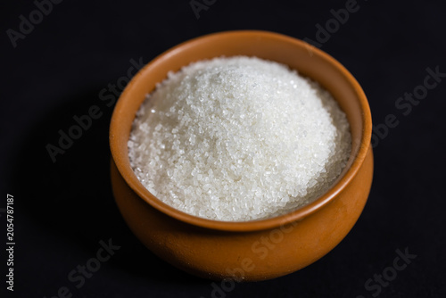 Фотография raw sugar crystals in ceramic bawl composition for food industry and kitchen ing