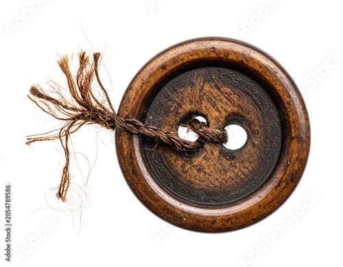 old vintage wooden button with four holes, with a piece of frayed brown thread sticking out, isolated on transparent background