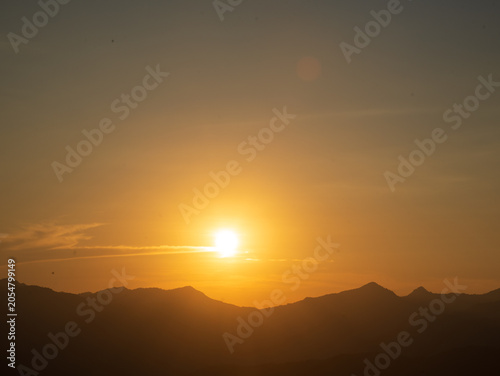 Beautiful landscape foggy hills twilight time. Blue golden sky sunrise dramatic beautiful landscape mountain. Dawn sky gold dusk time cloudscape with sunlight. Dramatic sunset over mountain landscape