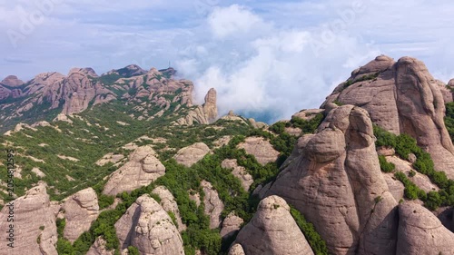 Panoramic view of unique rounded bulbous conglomerate rock formations and Mediterranean scrubland at Montserrat Natural Park, Catalonia, Spain with dramatic clouds