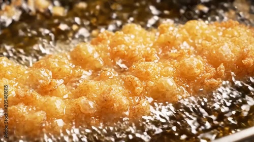 Crispy golden chicken cutlet frying in hot bubbling oil