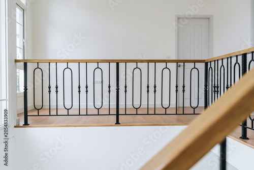 Bild auf Leinwand Modern interior railing with black metal balusters and wooden handrail in bright