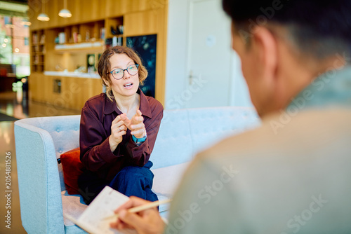 Canvas-taulu Female client describing her feelings and experiences to a male therapist taking