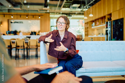 Fotografie Professional woman having a focused conversation, gesturing with hands during a