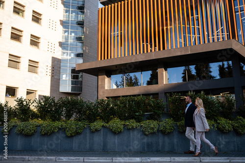 Photos Business people walking past modern corporate building