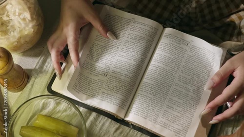 young conservative asian Woman Reading the Bible at table with bread food and drink indoors