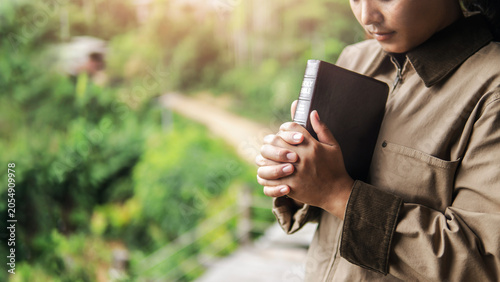 Obraz na płótnie A young woman prays to God, drawing upon scripture, concepts, faith, and praise of God, amidst nature