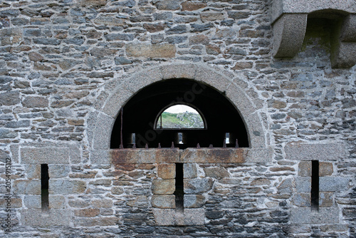 Foto Stone fortress wall with arched opening and defensive embrasures