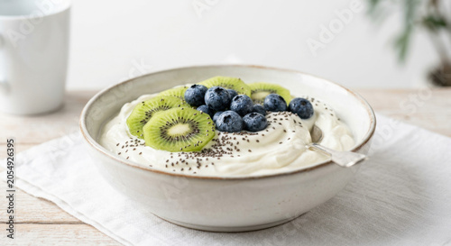 Creamy yogurt bowl with fresh kiwi slices and blueberries, a healthy and vibrant breakfast.