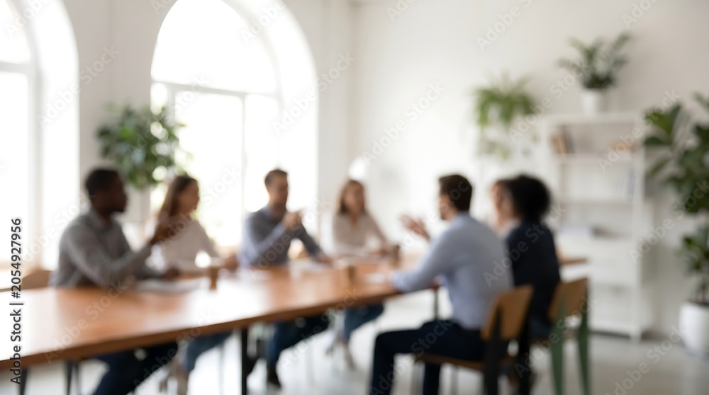 Fototapeta premium Diverse business team brainstorming during meeting in bright modern office space with blurred focus for professional corporate atmosphere and collaborative work environment concept